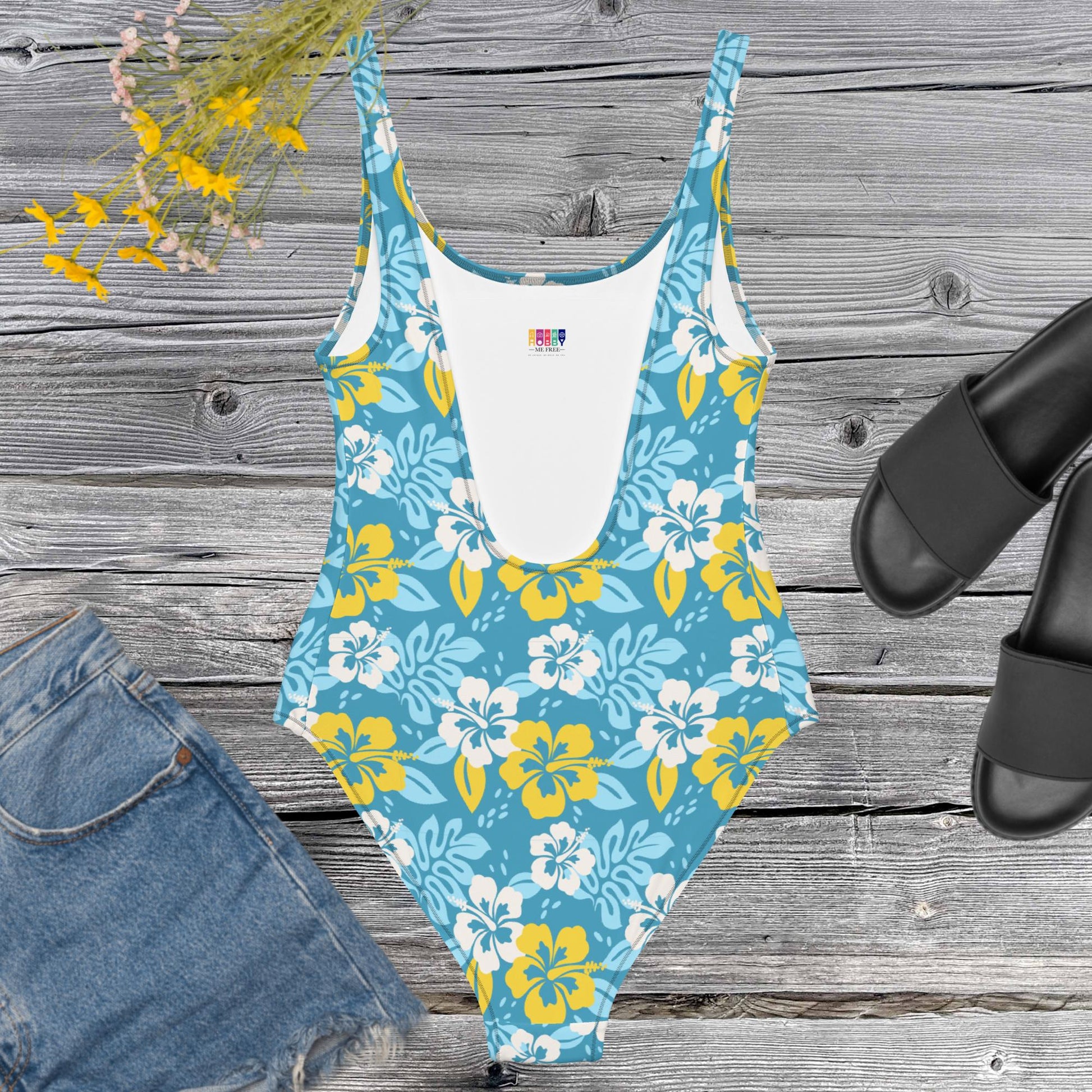 One piece all over print swimsuite with hawaian flowers on a blue background